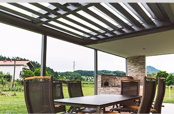 Überdachte Terrasse mit Esstisch und Stühlen im Garten.